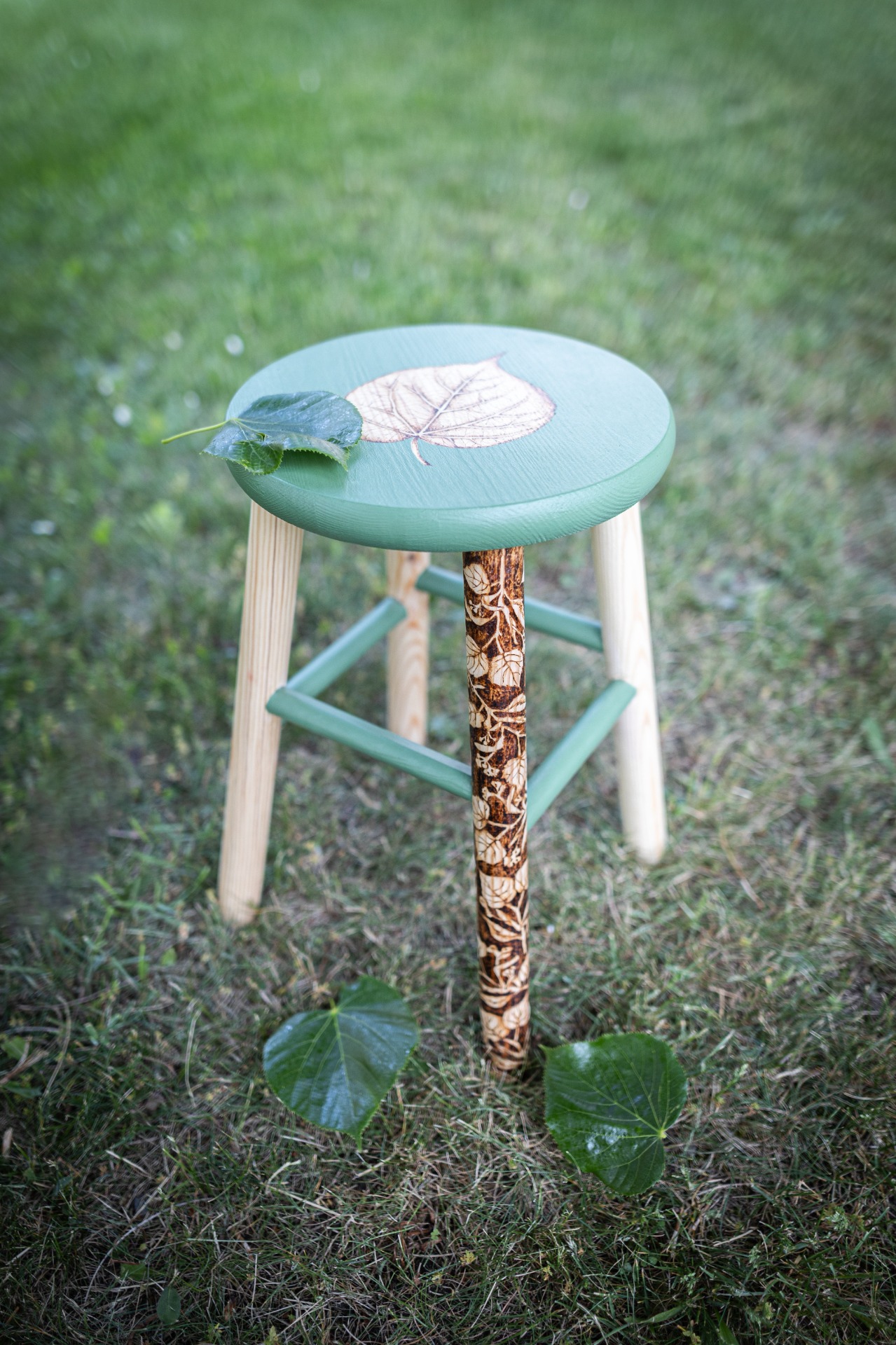 stolička s vypáleným motivem lípy v zelené barvě